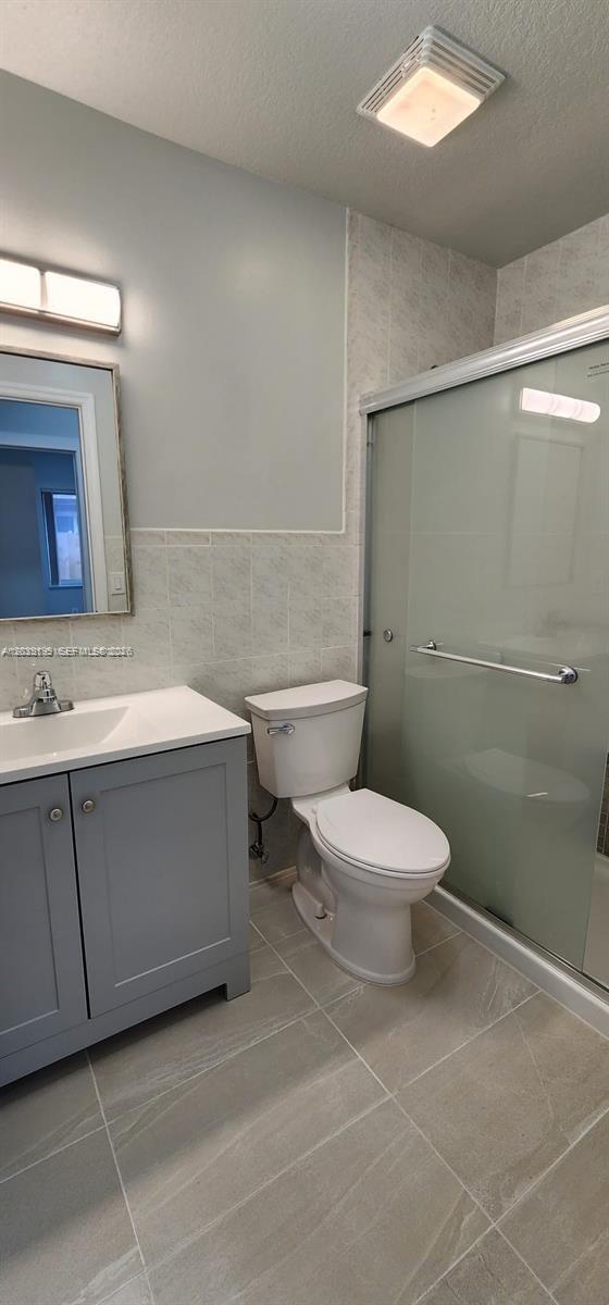 14817 Southwest 180th Street Miami, FL 33187 - Photo 10 of 15 a bathroom with a toilet a sink and mirror