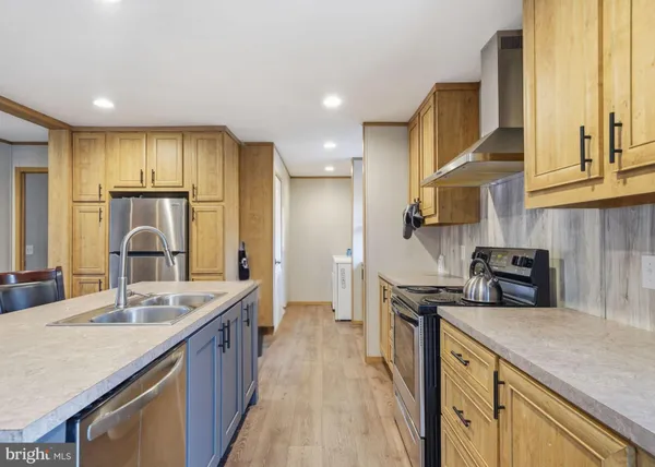 a kitchen with stainless steel appliances granite countertop a sink a stove and a refrigerator