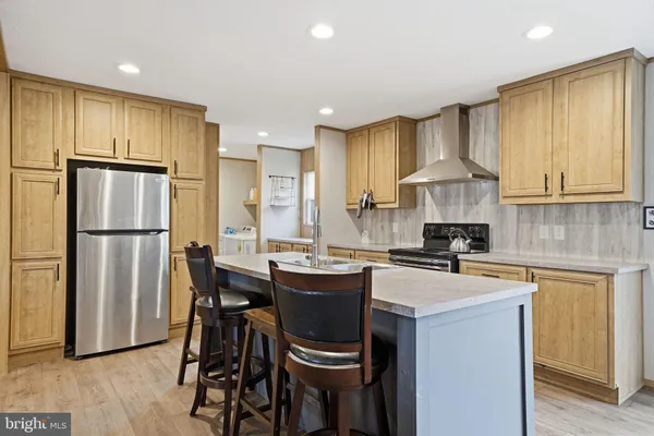 a kitchen with a sink a kitchen island and stainless steel appliances