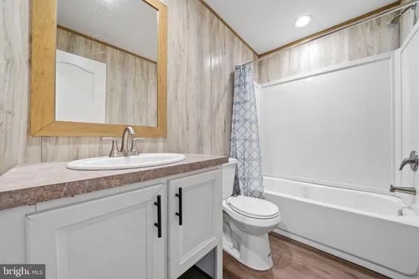 a bathroom with a granite countertop sink toilet a mirror and shower