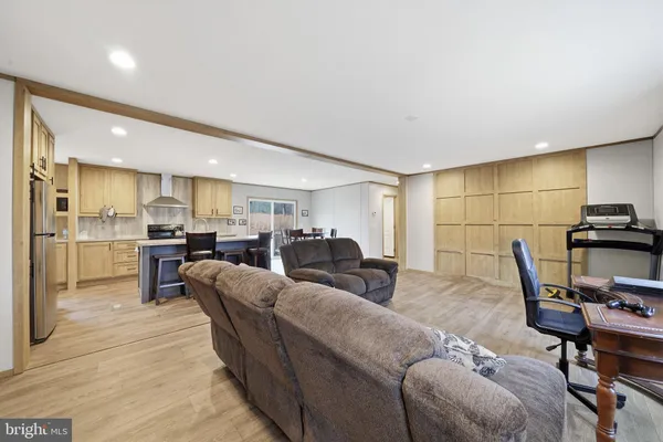 a living room with furniture a flat screen tv and a table