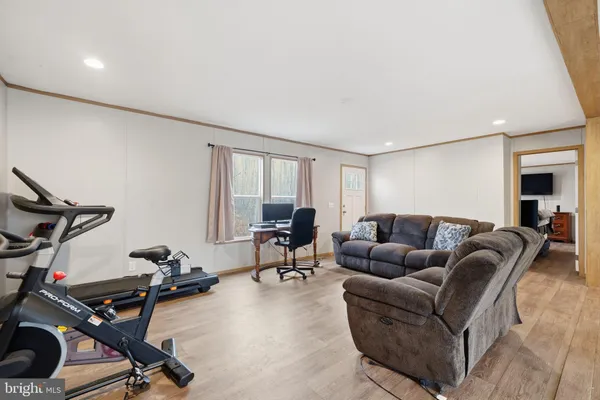 a living room with furniture gym equipment and a wooden floor