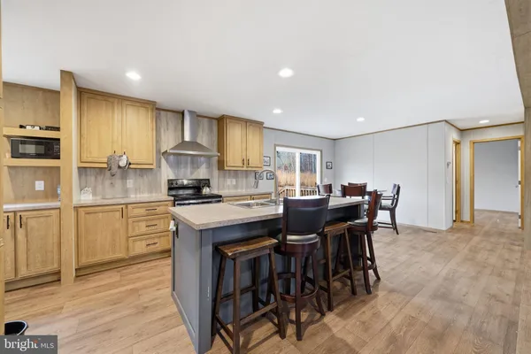 a kitchen with kitchen island granite countertop wooden floor dining table and chairs