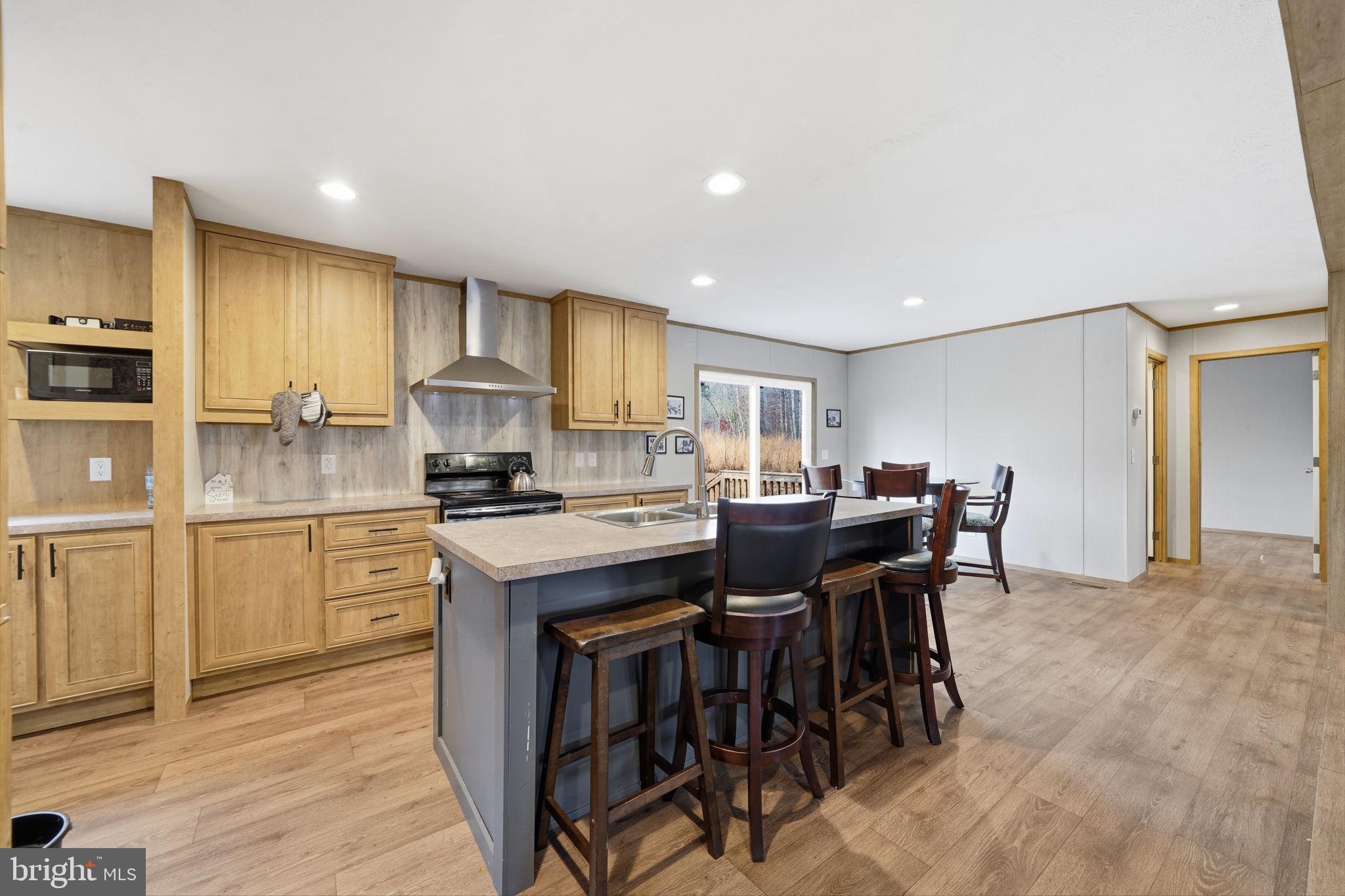 15075 Madison Run Road Gordonsville, VA 22942 - Photo 10 of 23 a kitchen with kitchen island granite countertop wooden floor dining table and chairs