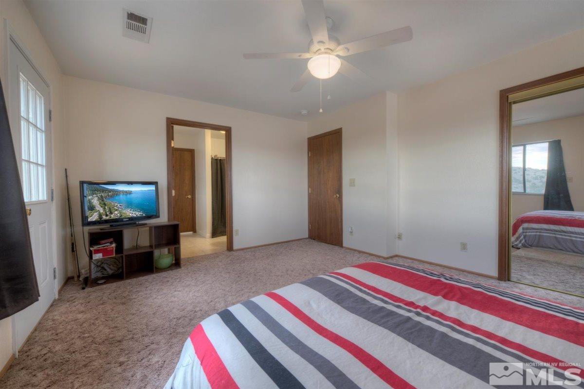 14007 North Red Rock Road Reno, NV 89508 - Photo 28 of 36 a living room with a bed and a flat screen tv