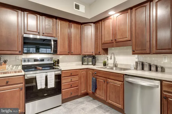 a kitchen with stainless steel appliances granite countertop a stove a sink dishwasher and a refrigerator