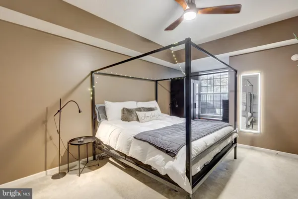 a bedroom with a bed and large mirror with a flat tv screen