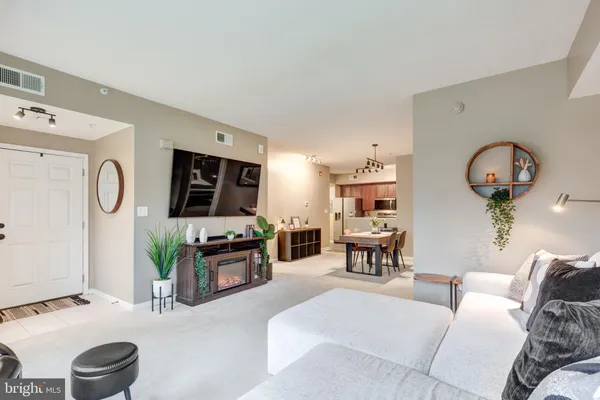 a living room with furniture a flat screen tv and a large window