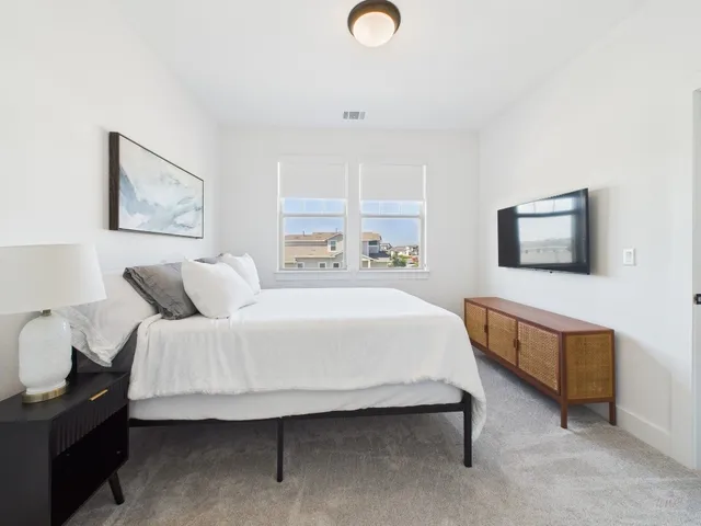 a bedroom with a bed and a night stand