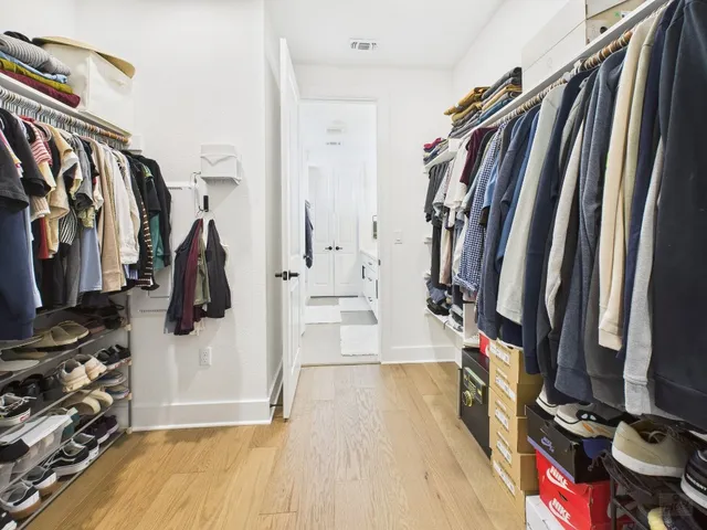 a view of walk in closet with clothes and shoes