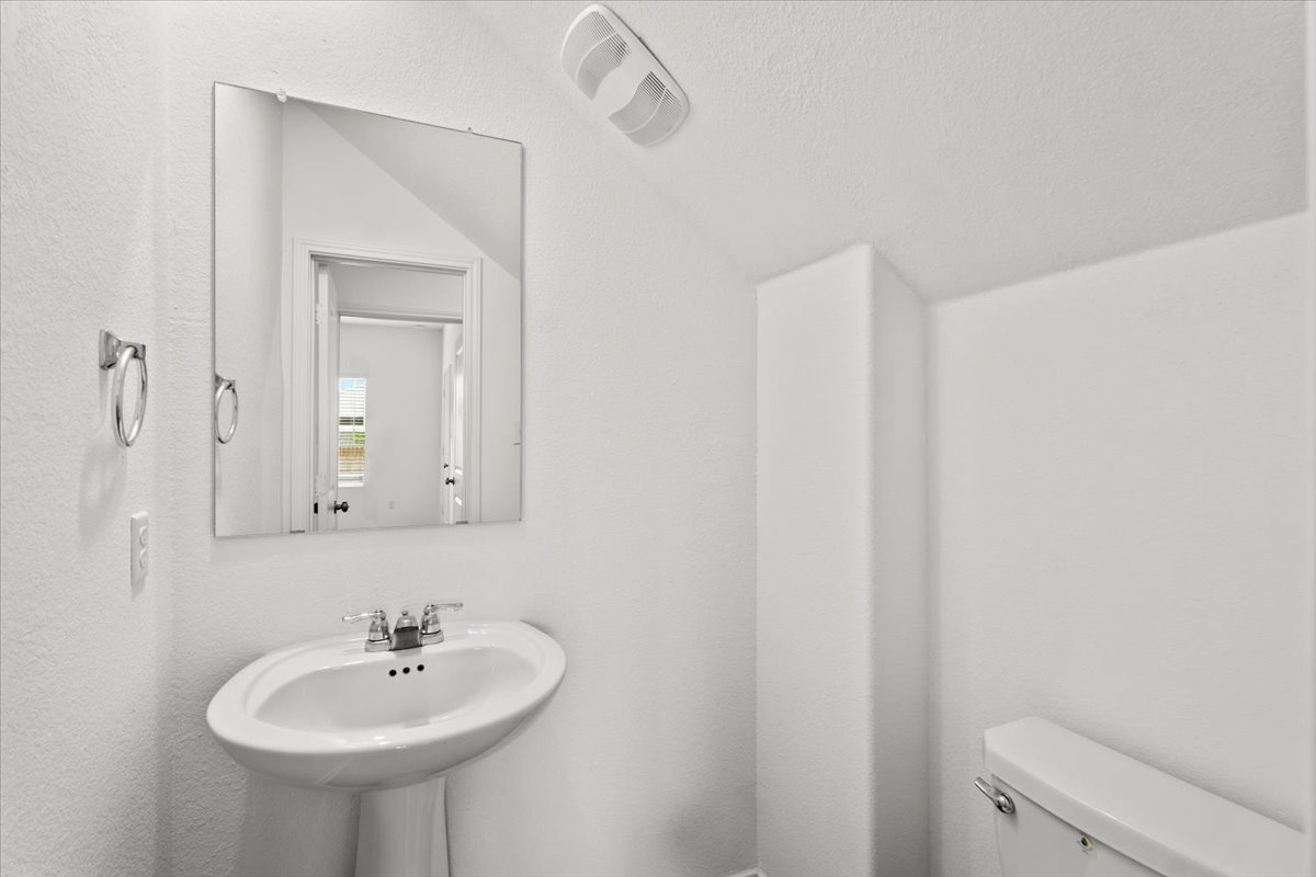 448 Perfect World Loop Jarrell, TX 76537 - Photo 23 of 40 A pristine powder room featuring a classic pedestal sink and simple, clean lines.