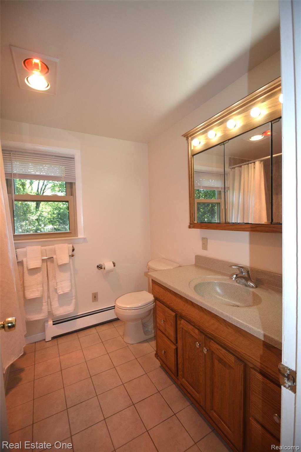 615 Willard Avenue Rochester, MI 48307 - Photo 15 of 30 Bathroom featuring a wood vanity with integrated sink, a large mirror with overhead lighting, a window with blinds, and tiled flooring