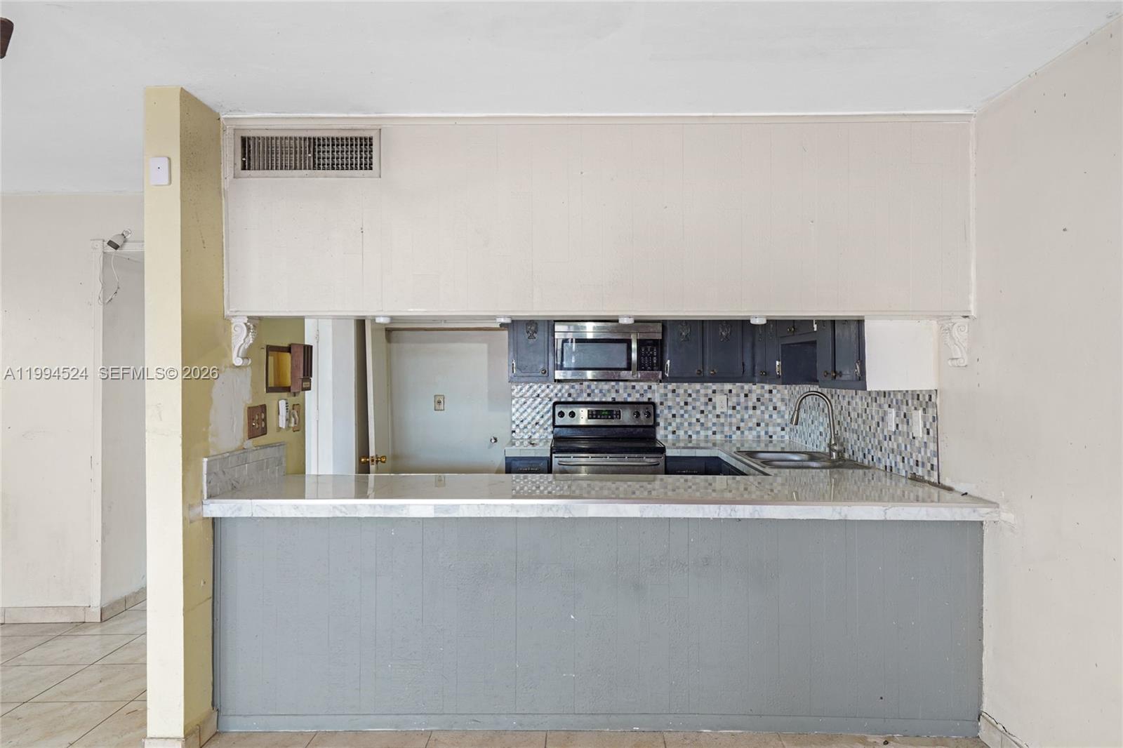7205 West 2nd Lane Hialeah, FL 33014 - Photo 15 of 30 a kitchen with stainless steel appliances granite countertop a sink and a refrigerator