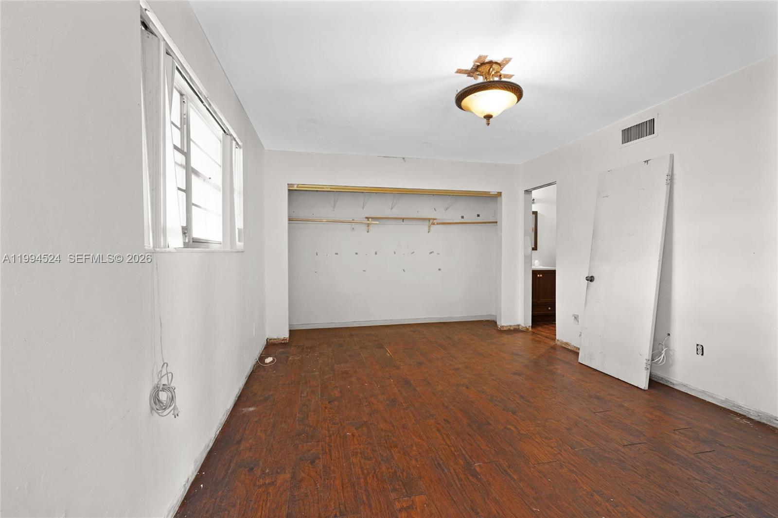 7205 West 2nd Lane Hialeah, FL 33014 - Photo 21 of 30 wooden floor in an empty room with a window