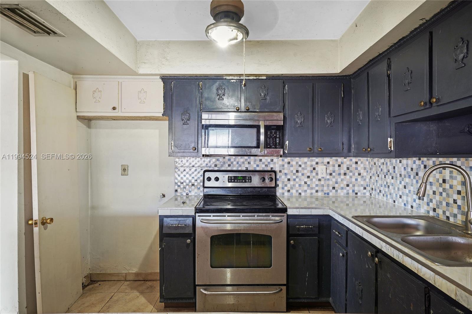 7205 West 2nd Lane Hialeah, FL 33014 - Photo 10 of 30 a kitchen with a stove and a sink
