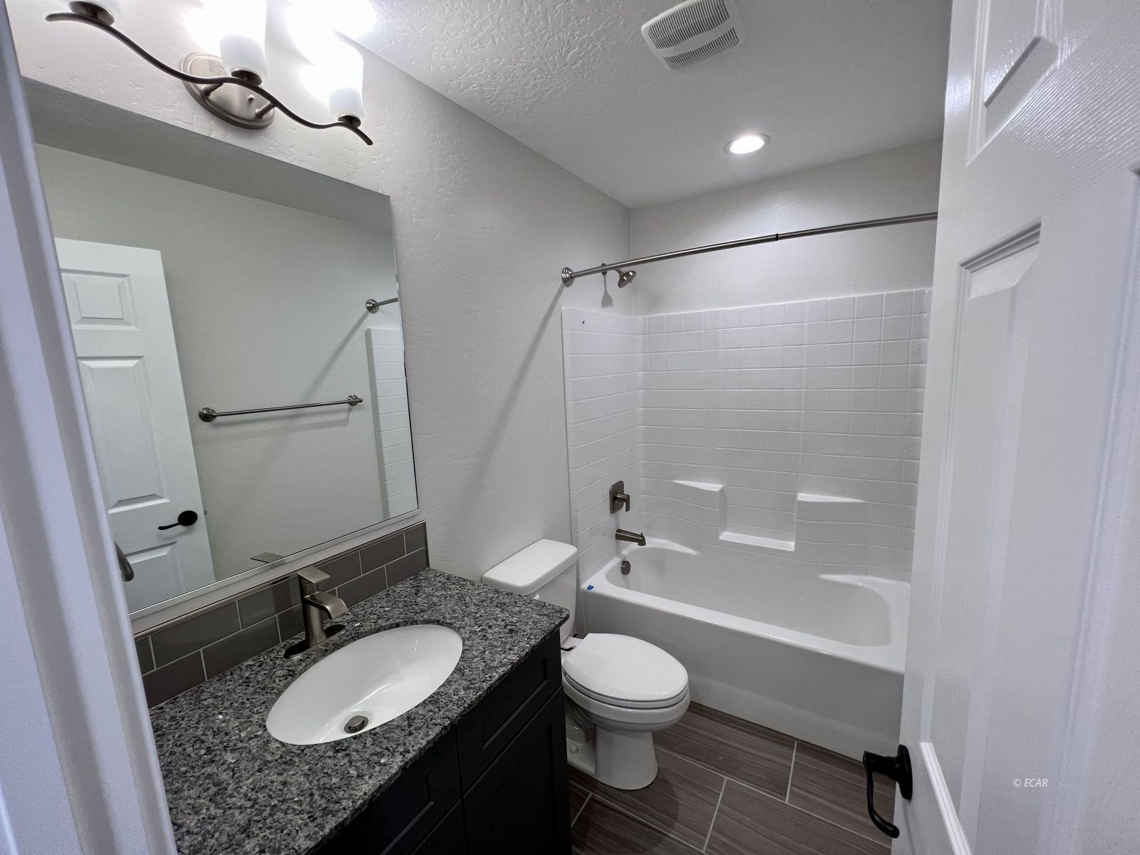 997 Sun Vly Road Spring Creek, NV 89815 - Photo 22 of 27 a bathroom with a granite countertop sink toilet a mirror and shower