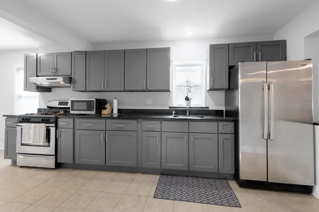 a kitchen with stainless steel appliances granite countertop a refrigerator sink and cabinets