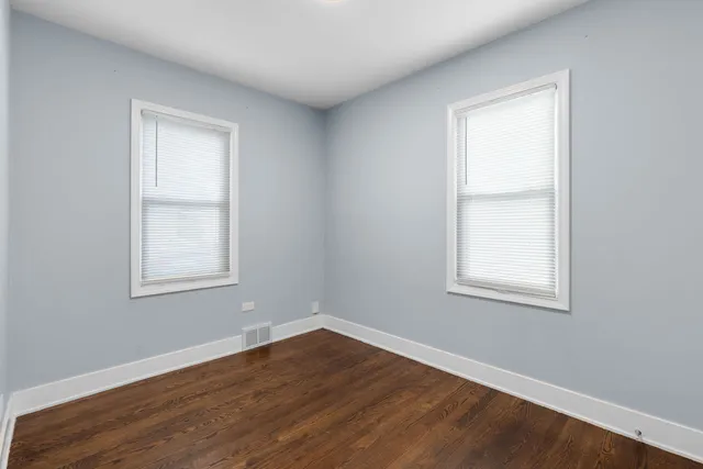 an empty room with wooden closet and a window