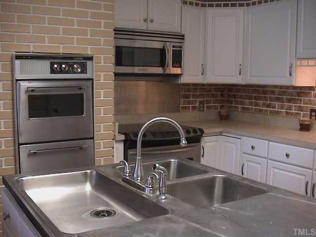 5405 Castlebrook Drive Raleigh, NC 27604 - Photo 7 of 12 a kitchen with granite countertop a sink stainless steel appliances and cabinets