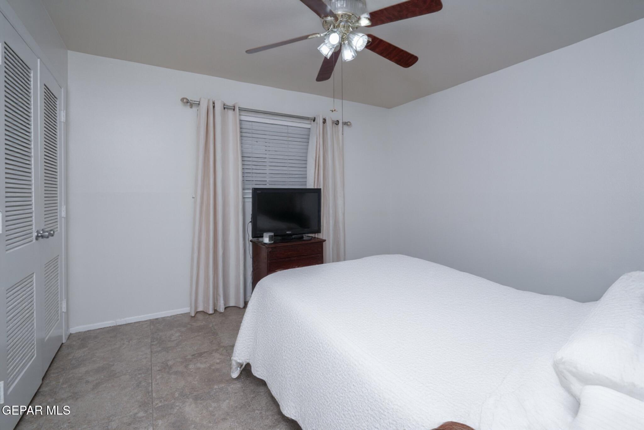 404 Butte Circle El Paso, TX 79902 - Photo 15 of 24 a bedroom with a bed and a chandelier