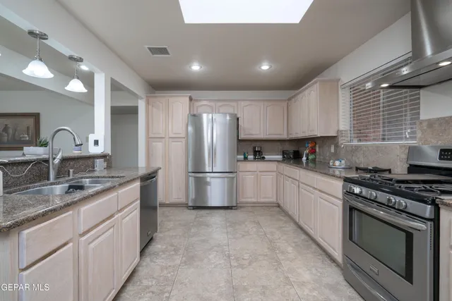 a kitchen with stainless steel appliances granite countertop a sink stove and refrigerator