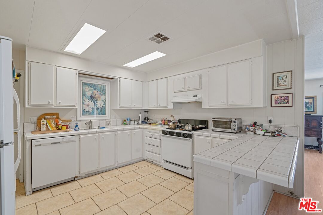 29500 Heathercliff Road, Unit 5 Malibu, CA 90265 - Photo 5 of 17 a kitchen with sink cabinets and stove top oven