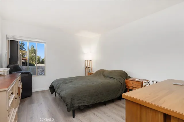 a bedroom with a bed and a flat tv screen on the dresser