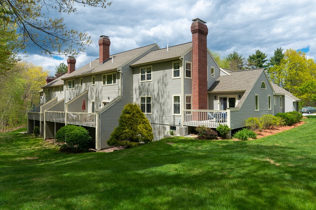 12 Wynridge Road, Unit 12 Windham, NH 03087 - Photo 4 of 40 a front view of a house with a garden and plants