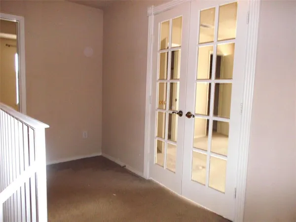 an empty room with windows and ceiling fan