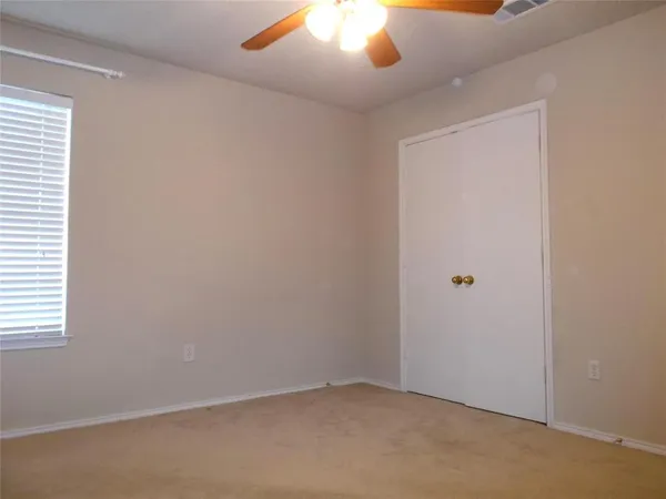 an empty room with a ceiling fan and a fan
