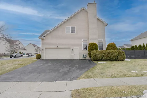 a view of a house with backyard and bushes