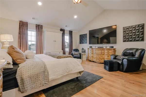 a bedroom with a bed a couch and a flat screen television