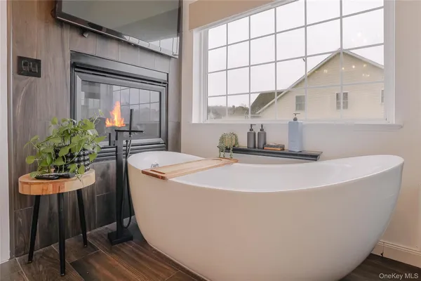a white bath tub sitting in a bathroom next to a window