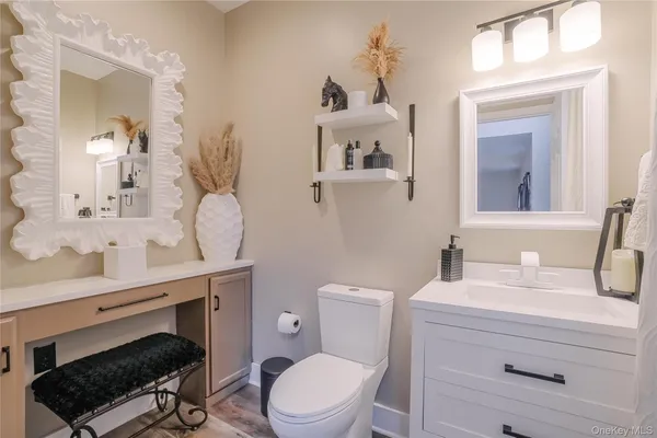 a bathroom with a sink vanity granite toilet and a mirror