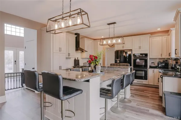 a kitchen with stainless steel appliances kitchen island granite countertop a table and chairs in it