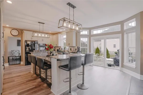 a view of a dining room and livingroom with furniture wooden floor a chandelier