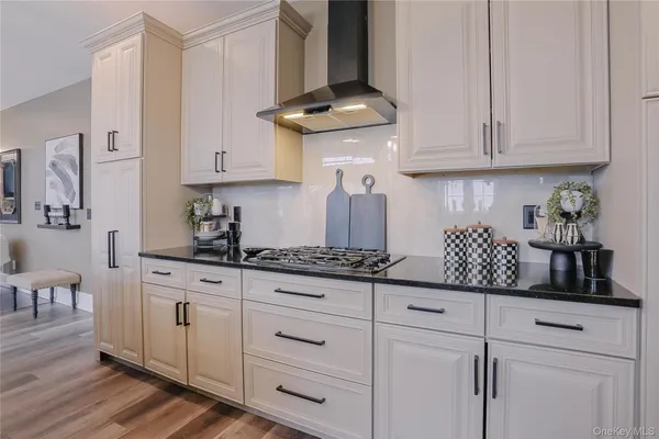 a kitchen with white cabinets and a stove