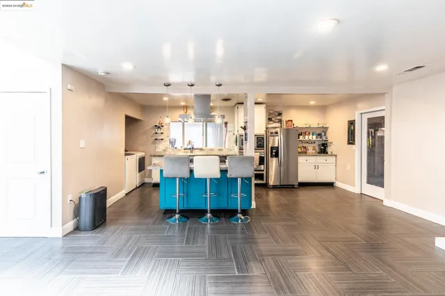 a kitchen with granite countertop kitchen island stainless steel appliances a sink and cabinets