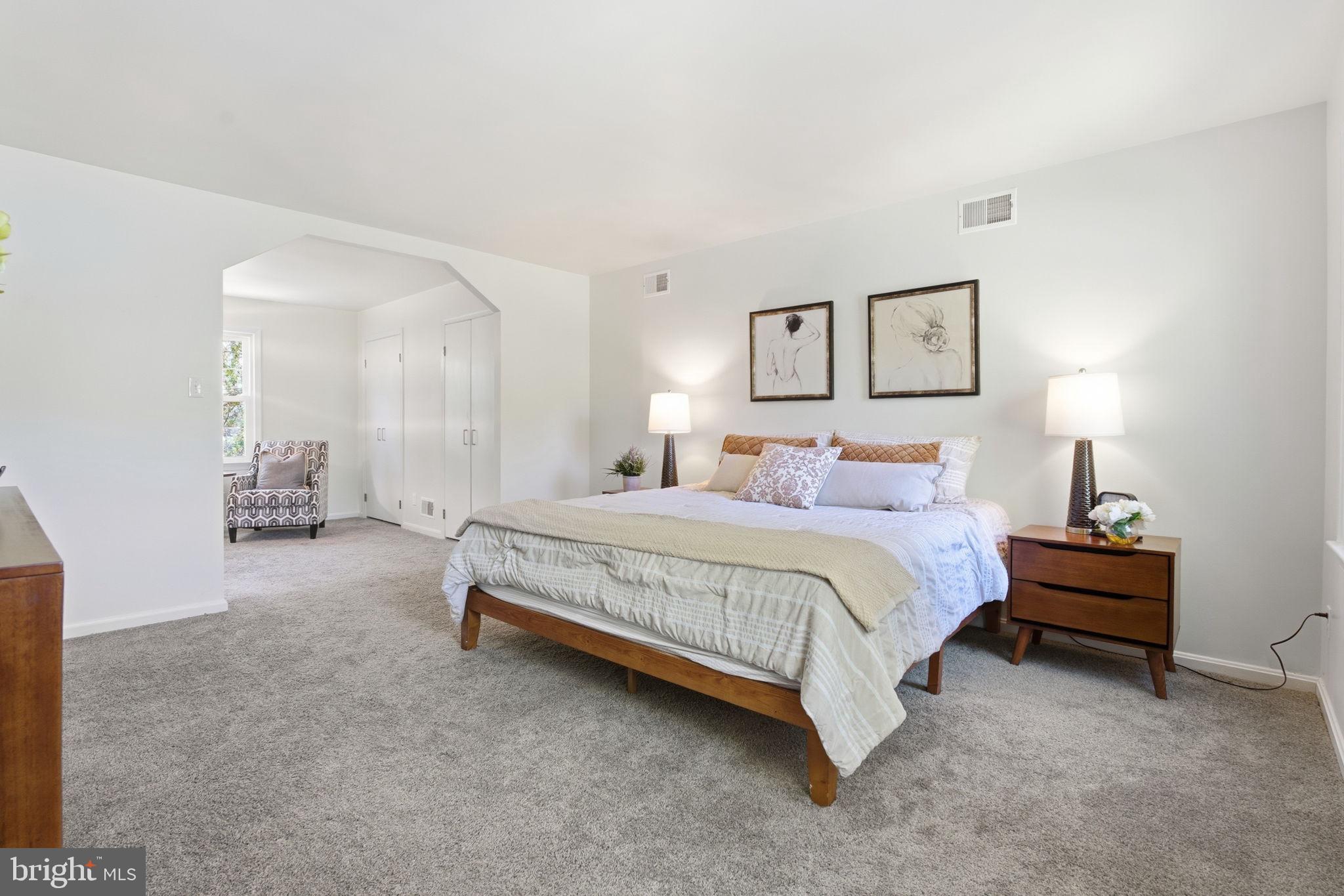 15101 Redgate Drive Silver Spring, MD 20905 - Photo 6 of 39 a spacious bedroom with a bed and a lamp