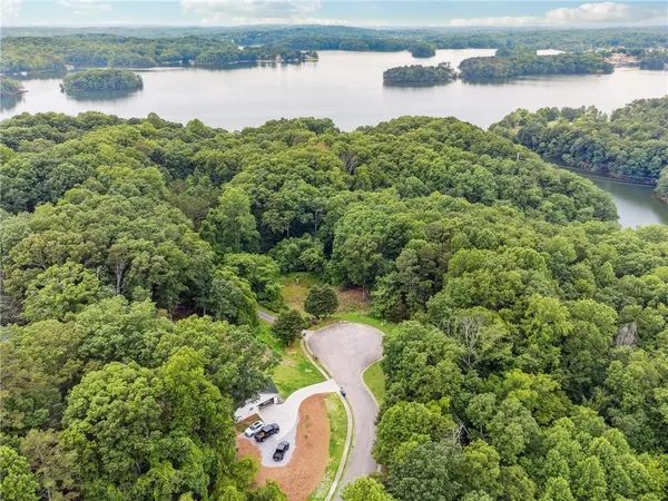 a backyard of a house with lots of green space and lake view