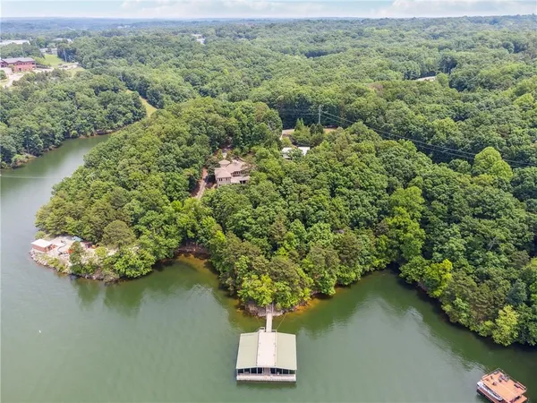 an aerial view of residential house with outdoor space and trees all around