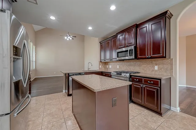 a kitchen that has a sink cabinets stainless steel appliances and a counter top space