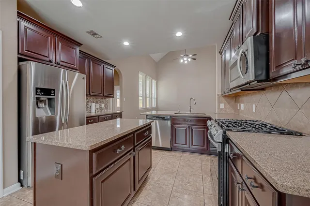 a kitchen with stainless steel appliances granite countertop a sink stove and refrigerator