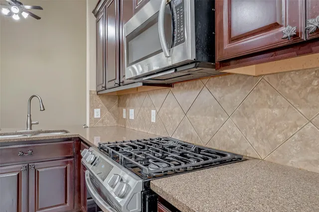 a kitchen with a stove a sink and cabinets