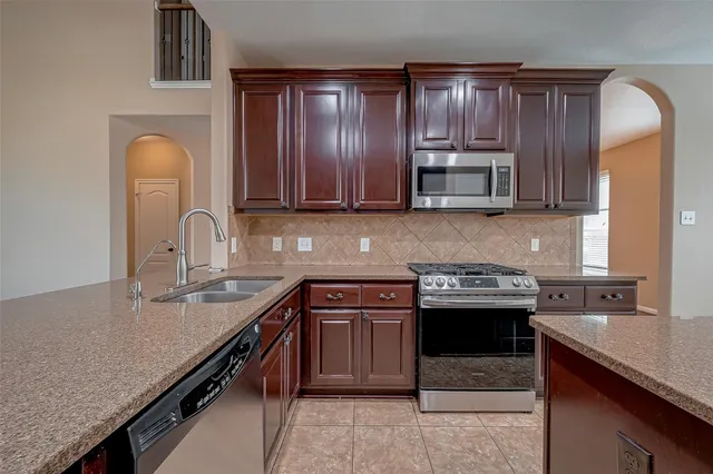 a kitchen with stainless steel appliances granite countertop a sink stove and refrigerator