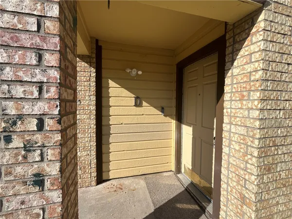 a view of a door and brick walls
