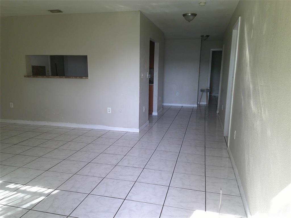Undisclosed Address Opa-Locka, FL 33054 - Photo 4 of 9 a view of a livingroom with an empty space and a window