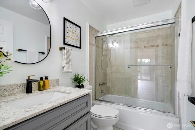 a bathroom with a granite countertop sink toilet and shower