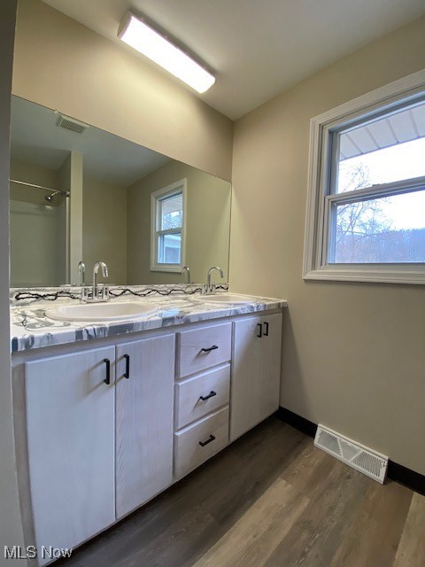 2868 Pressler Road Uniontown, OH 44685 - Photo 25 of 37 Full bath with double vanity, wood finished floors, visible vents, and a sink