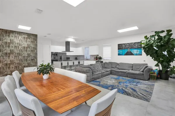 a kitchen with stainless steel appliances kitchen island granite countertop a table and chairs in it